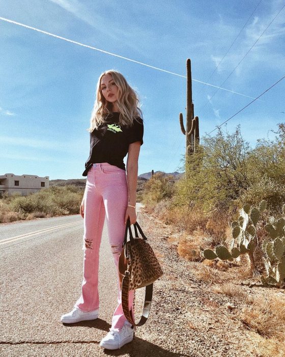 Chica con pantalones rosas y blusa negra 