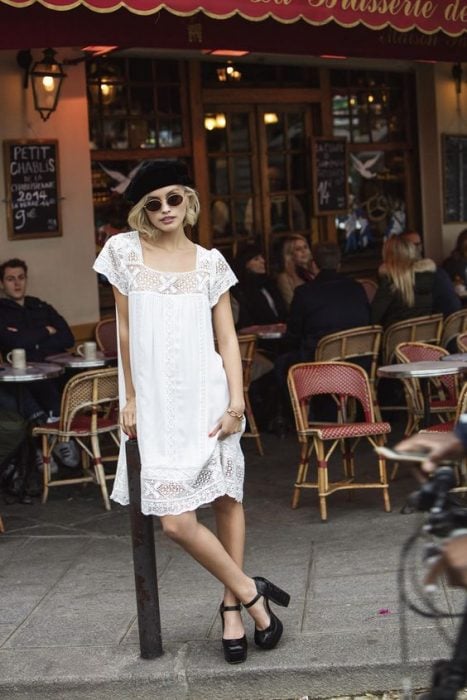 chica con vestido blanco veraniego tacones negros y boina negra