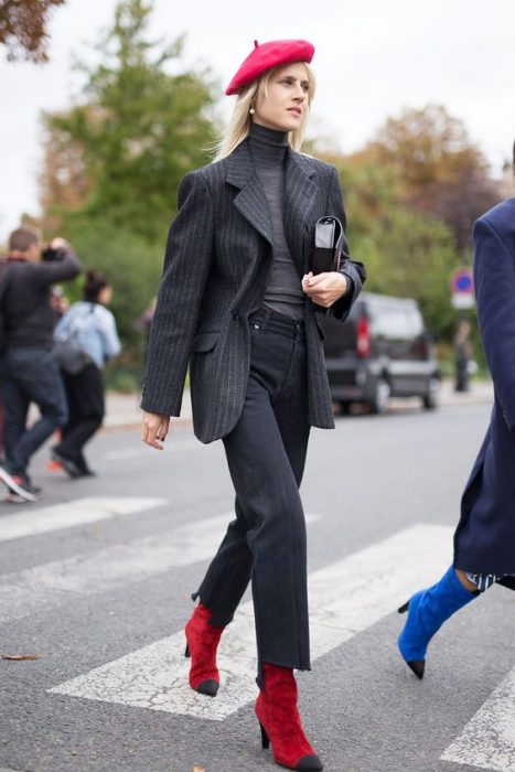 chica con pantalones de vestir blazer y blusa gris boina y botas rojas