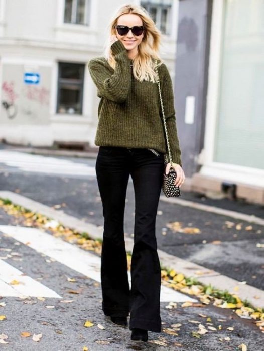 chica rubia con pantalones de campana negros y sueter verde