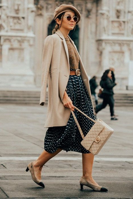 chica con falda de puntos, camisa, abrigo y boina camel