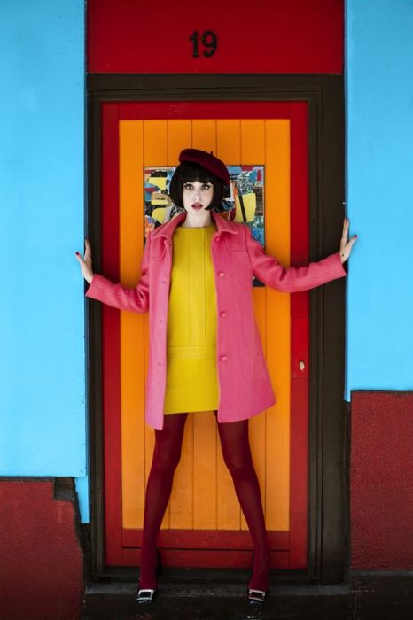 chica con boina y medias rojas vestido amarillo y abrigo rosa