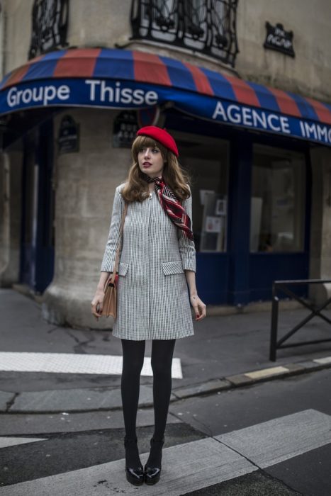 chica con medias, abrigo gris y boina roja