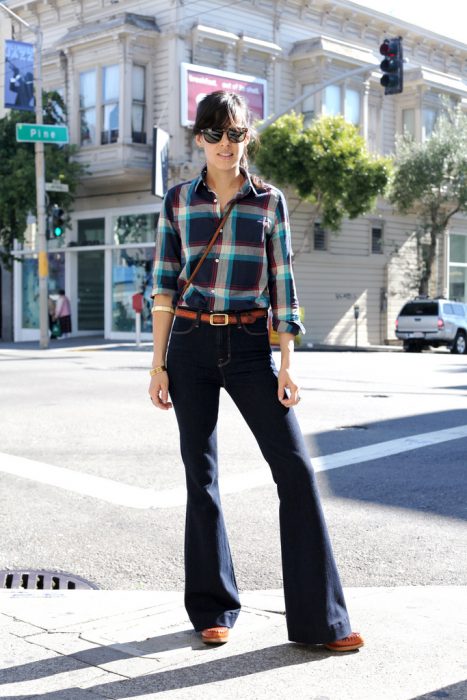 chica con pantalones de campana y cinto, camisa de cuadros