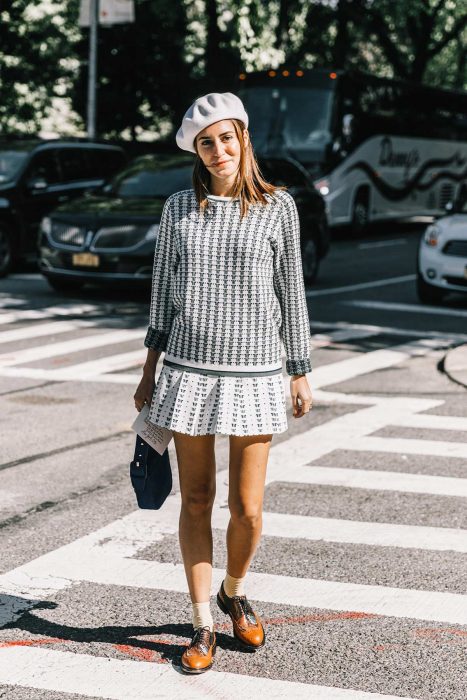 chica con falda blanca, sueter de dos colores y boina