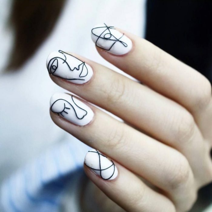 manicura blanca con figuras negras 