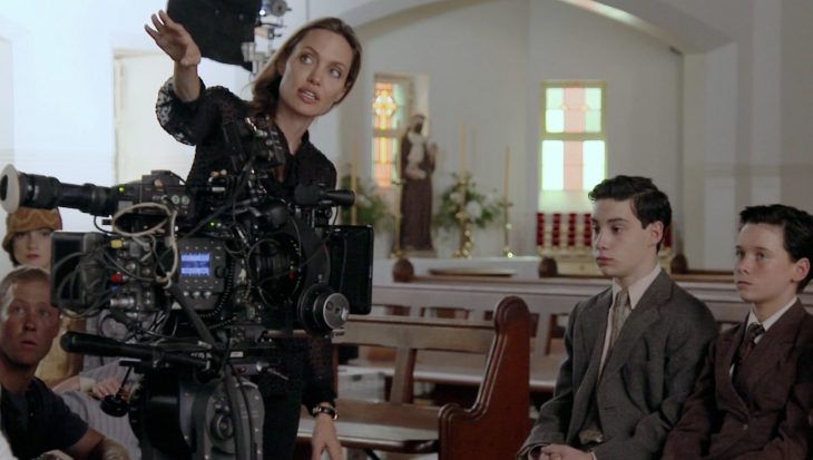 Angelina jolie junto a una camara dirigiendo una película 