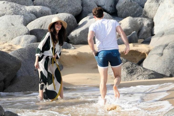 pareja de novios jugando en la playa 