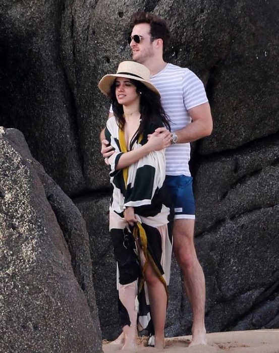 Pareja de novios abrazados en la playa