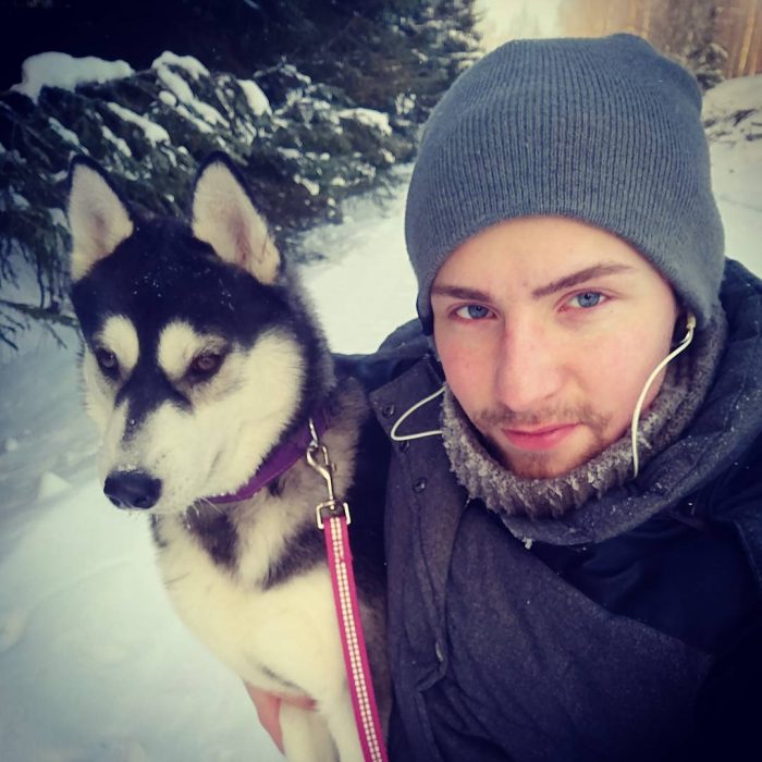 Chico sosteniendo a su perro y haciendo caras graciosas