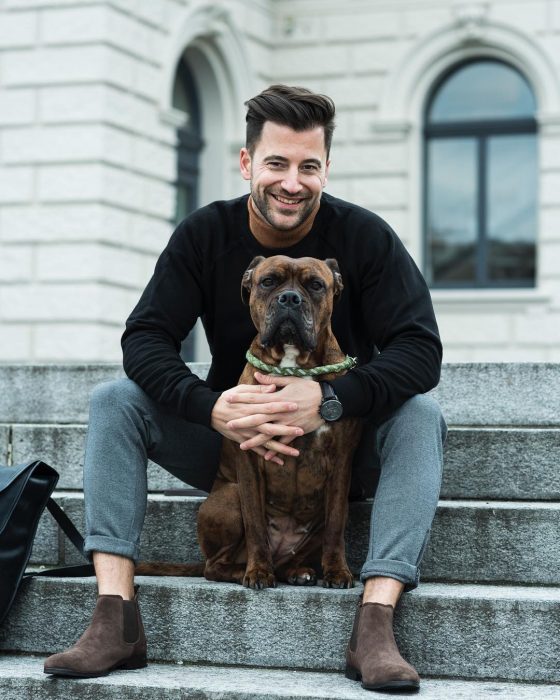 Chico sosteniendo a su perro y haciendo caras graciosas