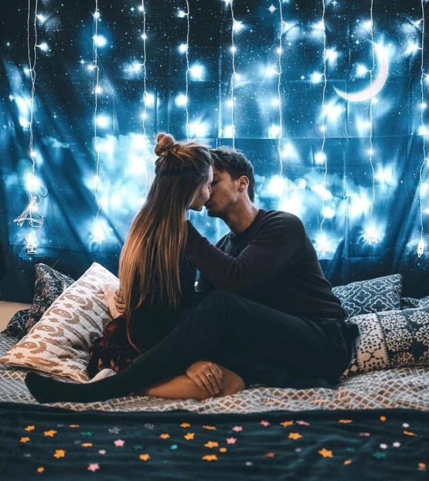 Pareja de novios besándose bajo las luces