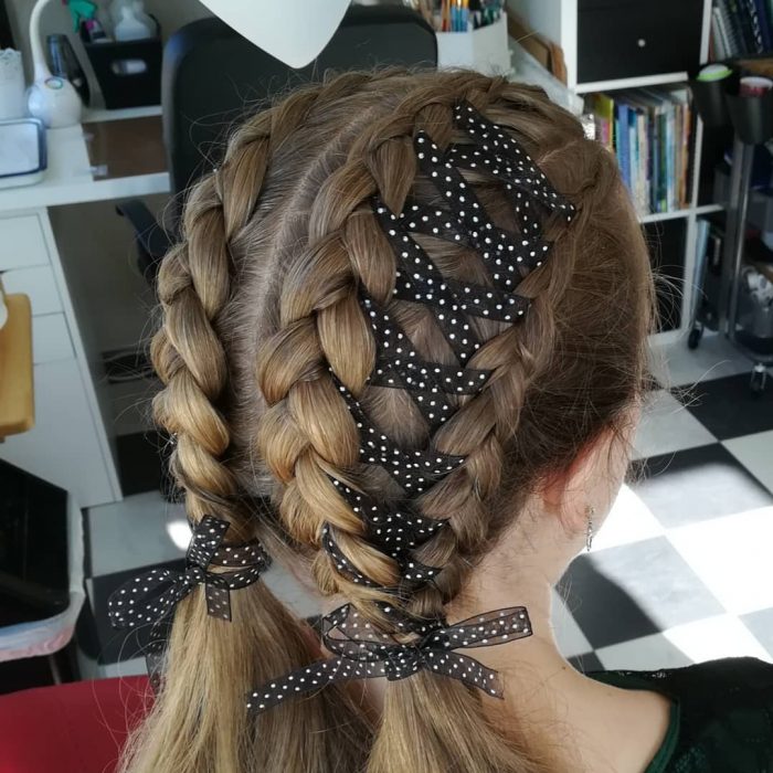 Chica usando unas corset braides dobles u adornadas con un listón negro y con puntos blancos 