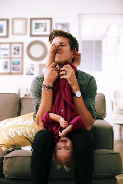 padre e hija jugando a las cosquillas