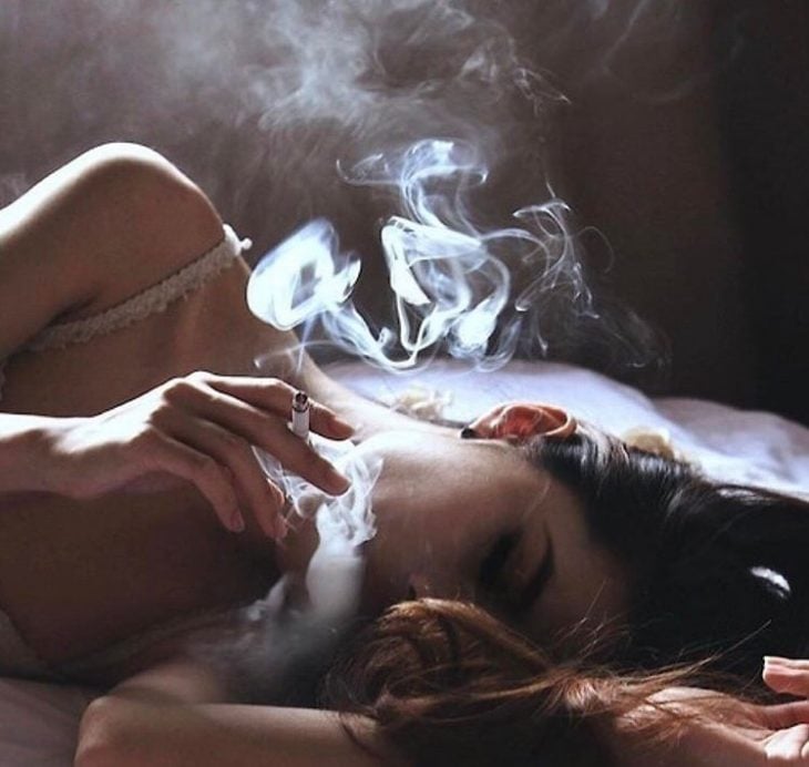 chica fumando en la cama