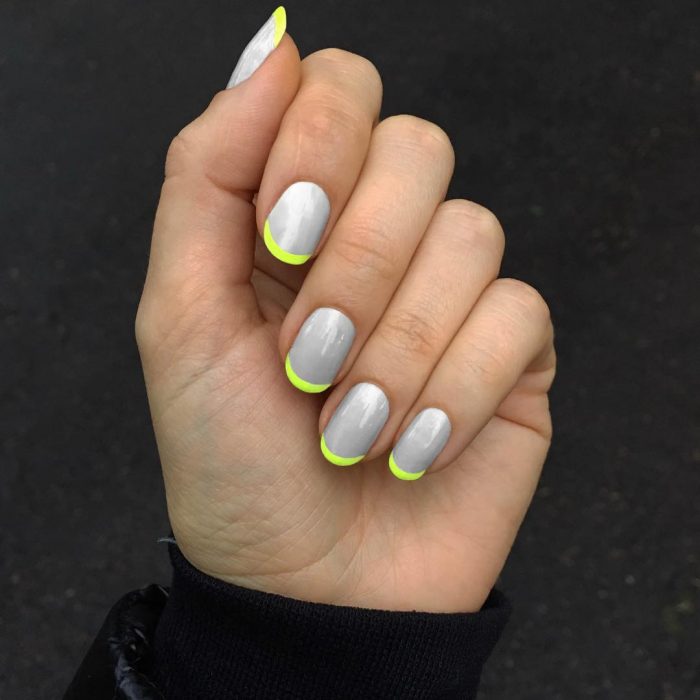 Diseños de uñas en color gris con una línea color amarillo neón 