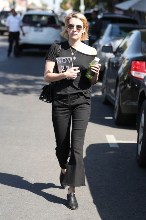 Emma Roberts caminando por la calle mientras usa un conjunto de color negro 