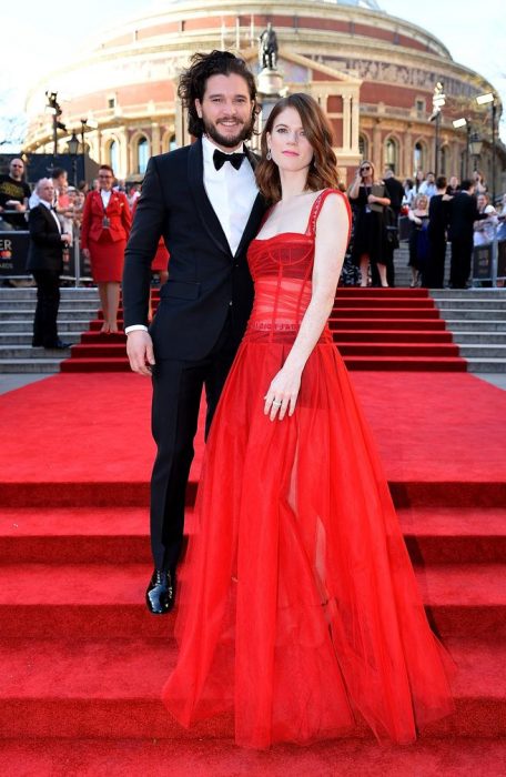 Kit Harrigton y su novia posando en una alfombra roja 