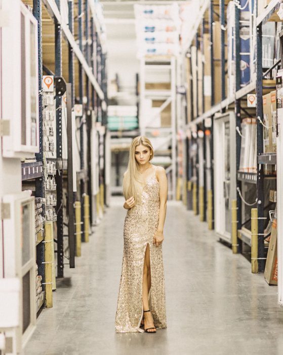 Chica posando para una sesión de fotos en una bodega enorme 