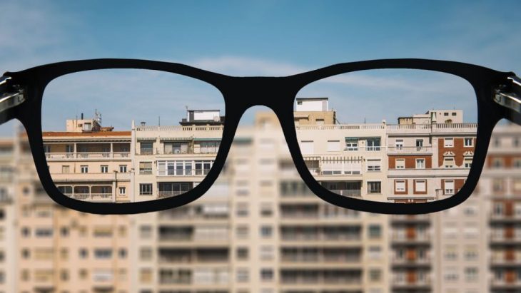 Lentes de una persona que sufre de miopía sobrepuestos con otra imagen donde se ve borroso 