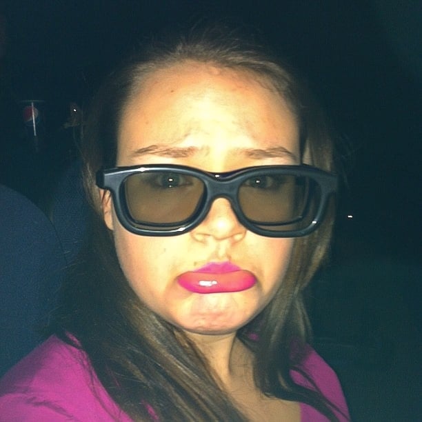 Chica poniendo sus lentes normales sobre otros lentes para ver películas en 3D