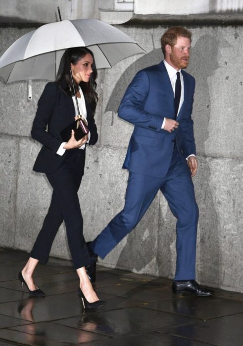 Meghan Markle y el príncipe Harry caminando bajo la lluvia