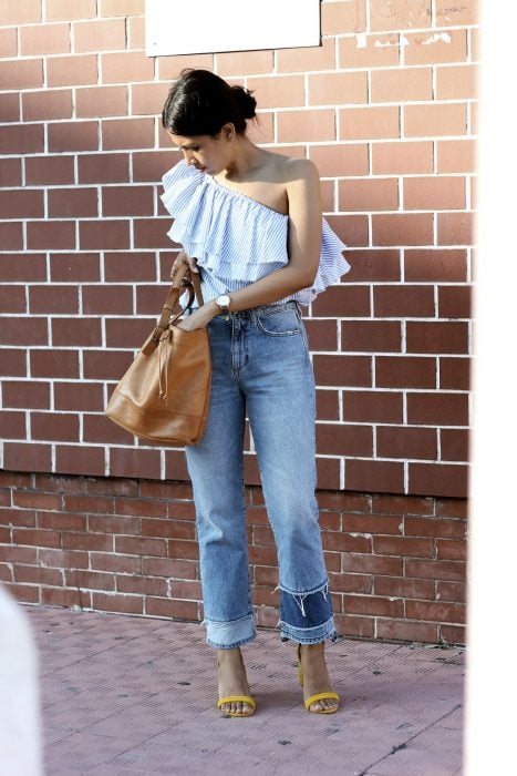Chica usando una camisa sin hombro y unos blue jeans color azul
