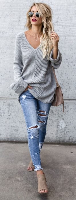 Chica usando unos jens rasgados con un cardigan