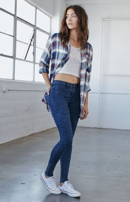 Chica usando unos jeans y camisa de leñador