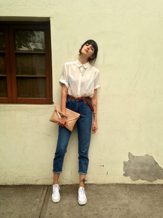 Chica usando unos jeans con camisa blanca 