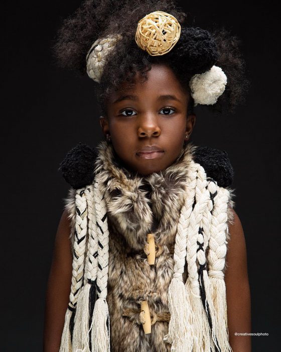 niña con cabello afro y ropa blanca 