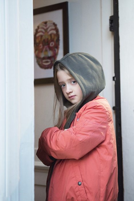 Niña que quiere ser modelo de Zara Boys posando con una chamarra de la marca 