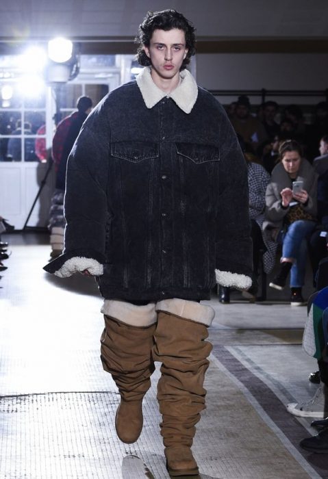 Chico desfilando en una pasarela durante la semana de la moda en parís usando unas botas ugg hasta el muslo 