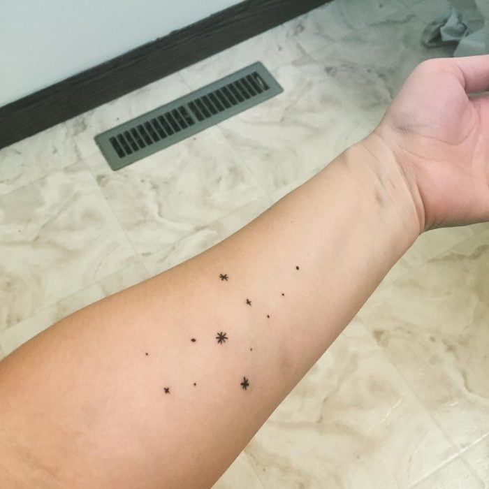 Chica con un tatuaje de estrellas en la mano 