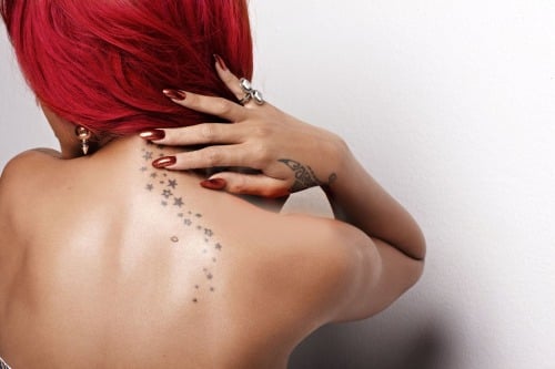 Chica con un tatuaje de estrellas en el cuello 