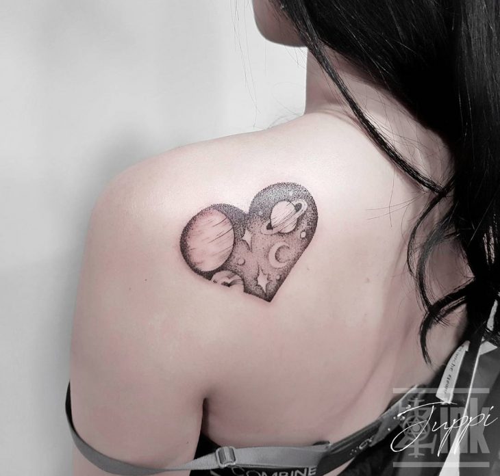 Chica con un corazón que tiene el universo como tatuaje 