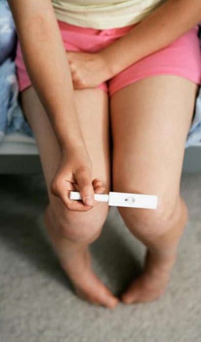 Chica sosteniendo una prueba de embarazo 