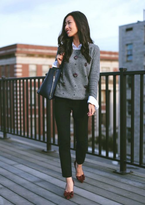 Chica usando una súeter de color gris leggings negros y zapatos elegantes con un moño rojo 