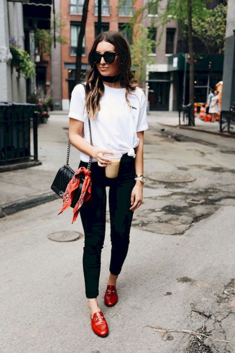 Chica caminando por la calle usando un outfit blanco y negro con zapatos rojos 