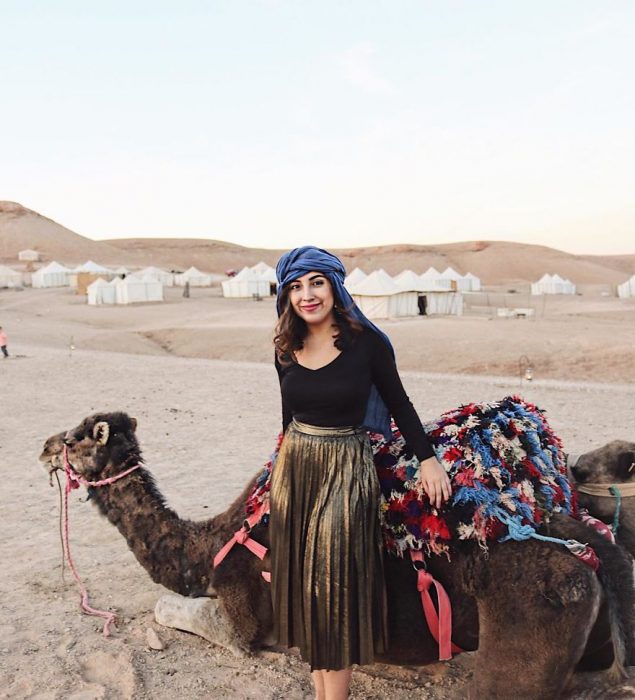 chica frente a un camello en el desierto