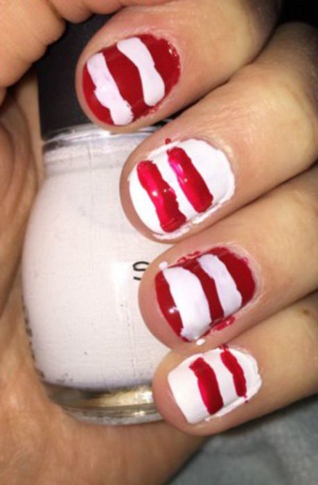 Chica con las uñas pintadas en blanco y rojo con las lineas raras