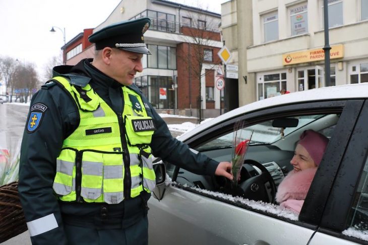 Policia regalando flores a una mujer 