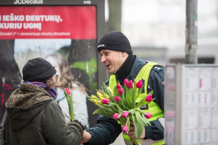 Policía entregando flores a las contudtoras