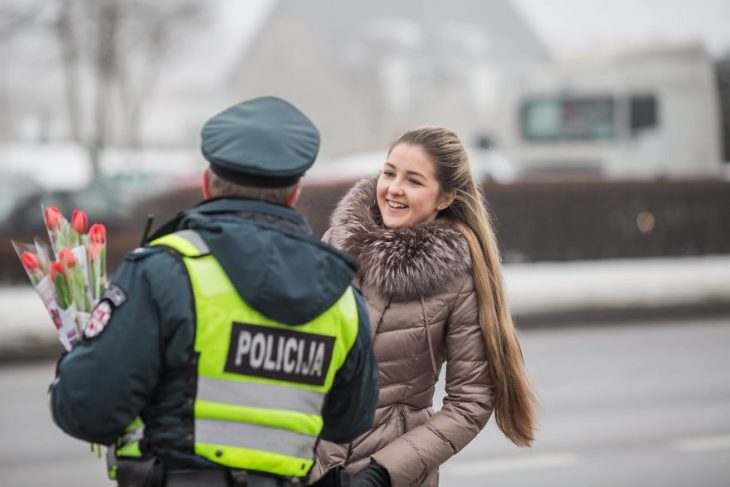 Policía entregándole una flor a una chica