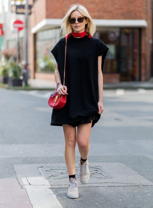 Chica usando un vestido negro con una mascada roja en el cuello 