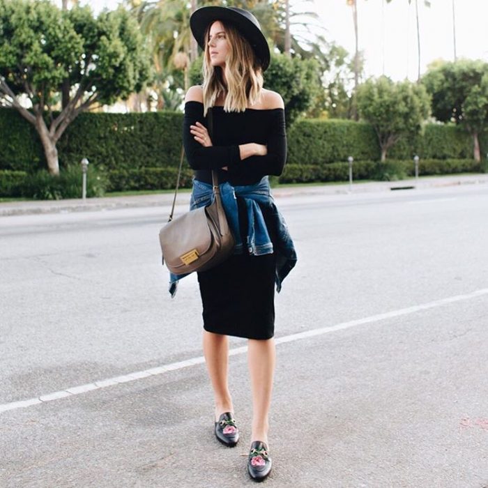 Chica usando un vestido negro con una chamarra de mezclilla y sombrero