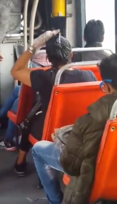 mujer pintando su cabello en el transporte publico 