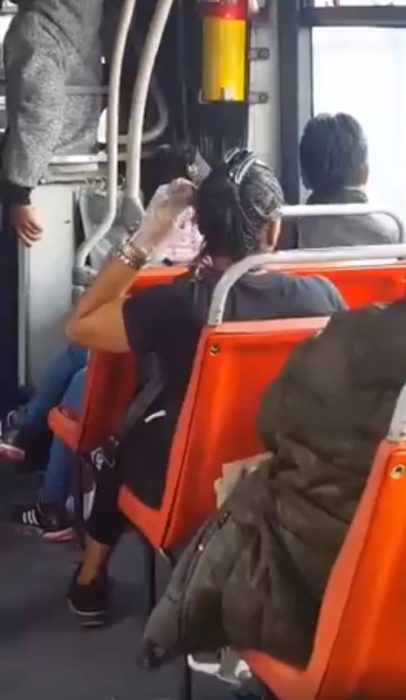 mujer pintando su cabello en el transporte publico 