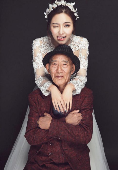 Chica vestida de novia posado junto a su abuelo 
