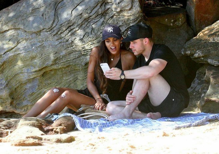 chicos en la playa viendo el móvil 